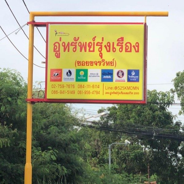 ป้ายหน้าอู่ทรัพย์รุ่งเรือง ซอยขจรวิทย์ พร้อมโลโก้บริษัทประกันและเบอร์โทร